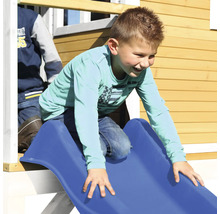Kind glijdt van een blauwe glijbaan van een speelhuis.