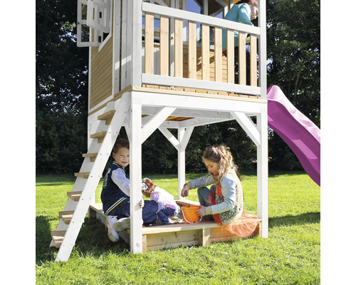 Speeltoren met glijbaan en zandbak voor kinderen in de tuin.