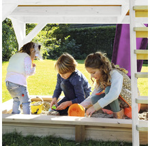 Kinderen spelen in een zandbak met dak en ladder in de tuin.