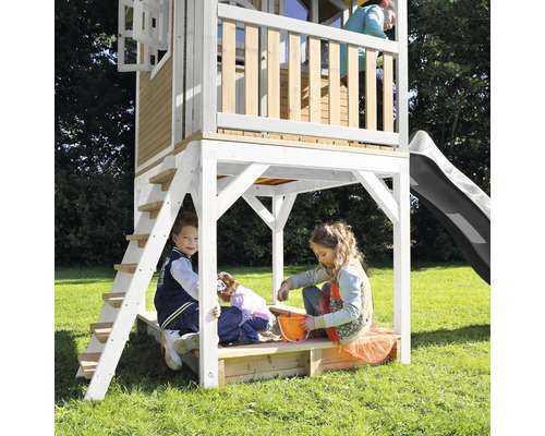 Speelhuis met glijbaan, ladder en zandbak voor kinderen in de tuin.