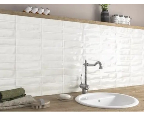 Badkamer met wastafel, kraan en witte wandtegels