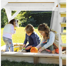 Kinderen spelen in de zandbak met dak en ladder in de tuin.