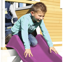 Jongen glijdt van een plastic speeltuinglijbaan.