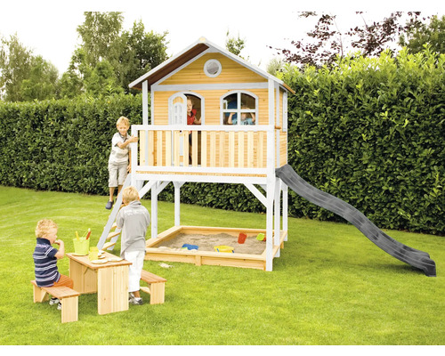 Houten speelhuis met glijbaan, zandbak en kinderzitgroep in de tuin