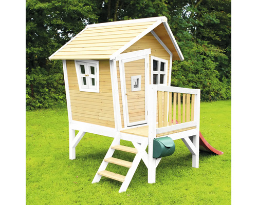 Houten speelhuis met glijbaan en brievenbus in de tuin