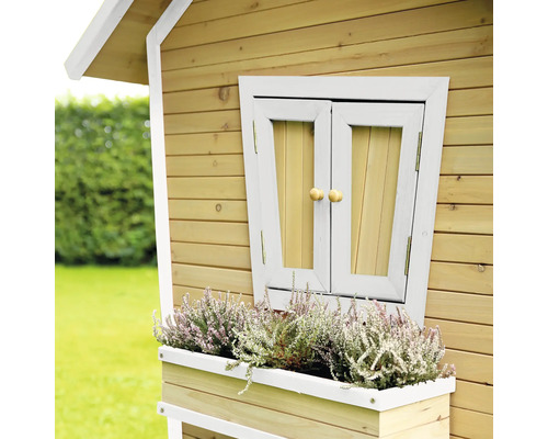 Detail van een speelhuis met houten gevel, luiken en bloembak