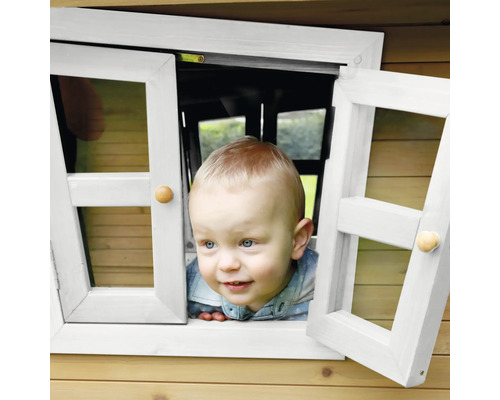 Kleine jongen kijkt uit het raam van een speelhuis.