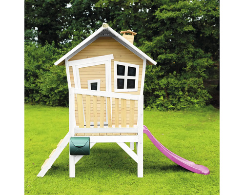 Speelhuis op palen met glijbaan, trap en brievenbus in de tuin