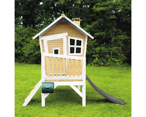 Houten speelhuis met glijbaan en brievenbus in de tuin