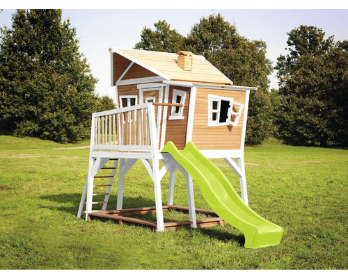 Houten speelhuis met glijbaan in de tuin.