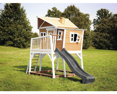 Houten speelhuis met glijbaan en ladder in de tuin