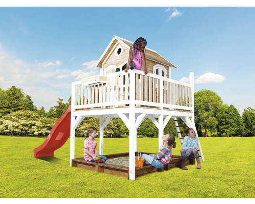 Speelhuis met glijbaan, zandbak en kinderen op een gazon.