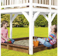 Twee kinderen spelen in een zandbak met speelhuis in de tuin.