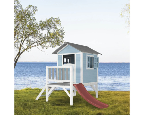 Houten speelhuis met glijbaan in de tuin met uitzicht op zee