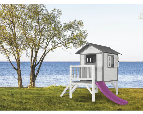 Houten speelhuis met glijbaan in de tuin