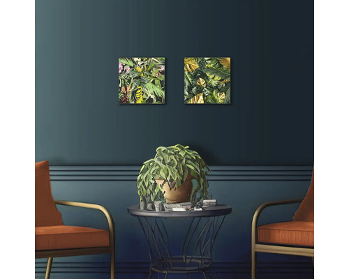 Decoratieve woonkamer met twee plantenfoto''s, tafel, potplant en twee stoelen