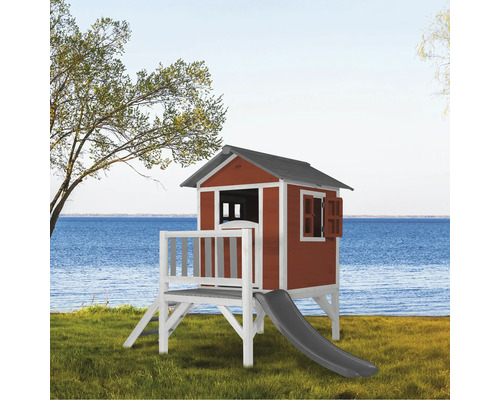 Houten speelhuis met glijbaan aan een meer