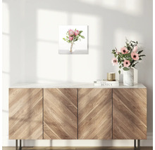 Wanddecoratie met bloemstuk boven houten kast