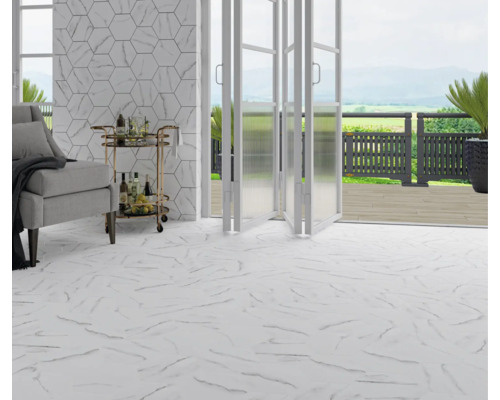 Licht interieur met marmerlook tegelvloer, fauteuil, serveerwagen en open deur naar het terras