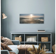 Woonkamer met muurdecoratie van een besneeuwd boslandschap in de mist.
