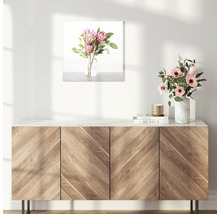 Decoratieve afbeelding met bloemstuk boven een houten kast.