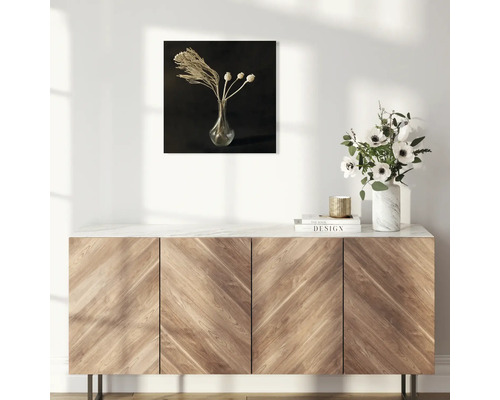 Decoratieve wandkunst met bloemstilleven boven een houten kast