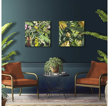 Woonkamer met twee fauteuils, een tafeltje en twee decoratieve schilderijen met plantmotieven aan de wand