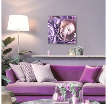 Woonkamer met paarse bank en bloemenschilderij aan de muur