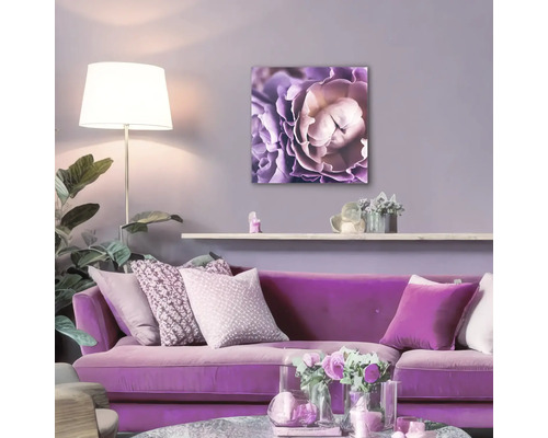 Woonkamer met paarse bank en bloemenschilderij aan de muur
