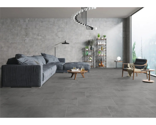 Lichte woonkamer met grijze vloertegels, bank, fauteuils en rekken