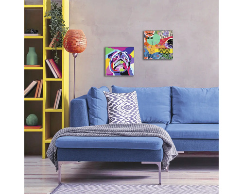 Woonkamer met blauwe bank, gele kast en schilderijen