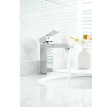 Moderne metalen kraan in de badkamer met stromend water.