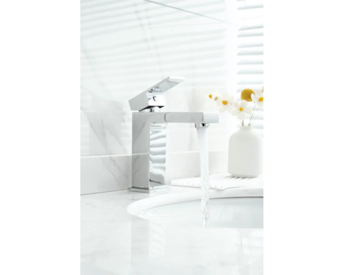 Moderne metalen kraan in de badkamer met stromend water.