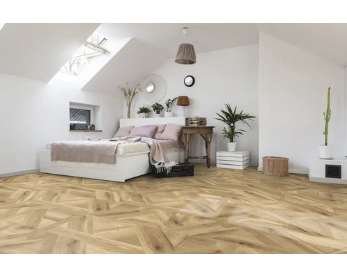 Slaapkamer met dakraam, bed en houten vloer in visgraatmotief