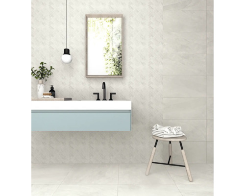 Badkamer met wastafel, spiegel en kruk voor een betegelde muur