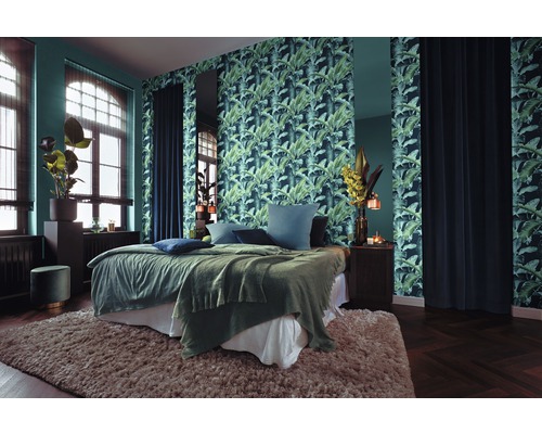 Slaapkamer met bed, nachtkastje, behang met plantmotief en vloerkleed