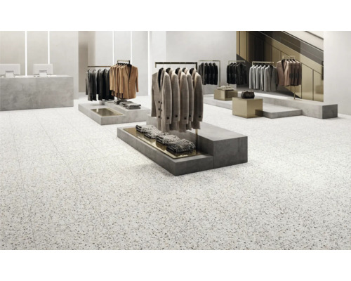 Tegelvloer in een kledingwinkel met kledingrekken.