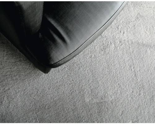 Detailopname van een zwarte bank op een lichtgekleurd tapijt