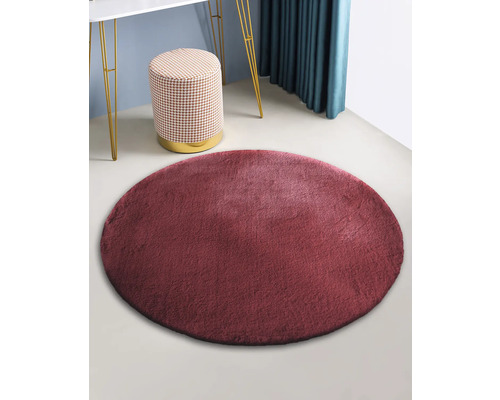 Rond imitatievacht tapijt in kamer met kruk en tafel