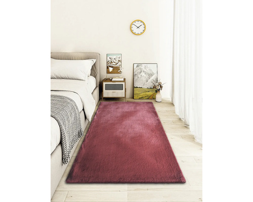 Rechthoekig tapijt voor een bed in de slaapkamer.