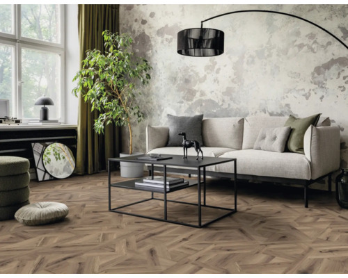 Woonkamer met bank, tafel, kamerplant en houten vloer in visgraatmotief