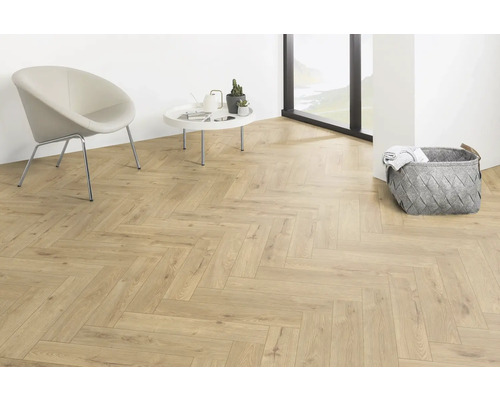 Lichte kamer met visgraatparket, stoel, tafel en opbergmand