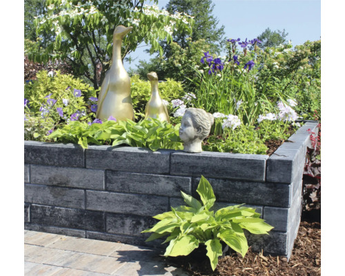 Verhoogde stenen plantenbak met planten en decoratie