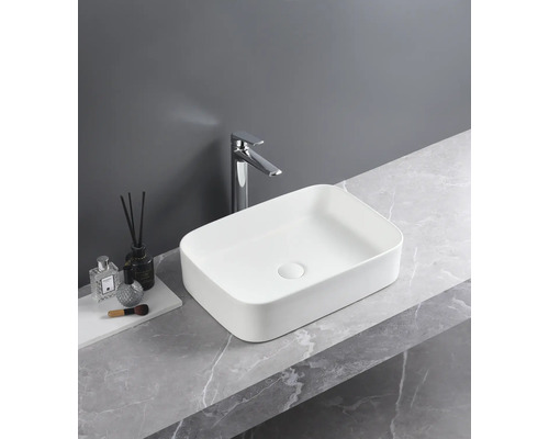 Rechthoekige keramische waskom met kraan op een marmeren blad