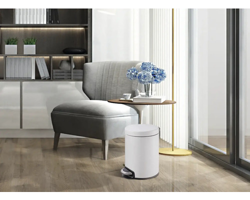 Scene van een woonkamer met een witte pedaalemmer op de voorgrond