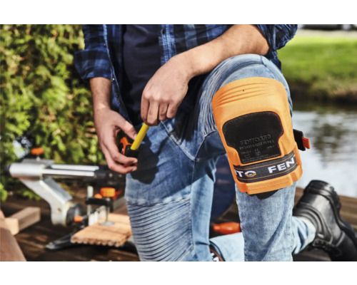 Ambachtsman met kniebeschermers aan het werk met een decoupeerzaag