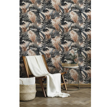 Woonkamer met patroonbehang, houten stoel, deken en bijzettafel