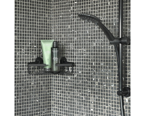 Douchescène met douchekop, douchestang en doucherek met verzorgingsproducten aan een betegelde muur