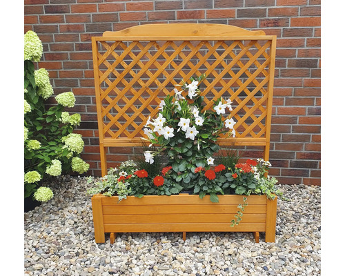Houten plantenbak met klimrek en bloemen op grind