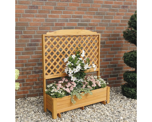 Bloembak met klimrek en beplanting voor een bakstenen muur